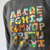 Gray sweatshirt with colorful alphabet letters on a plain background