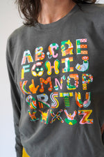 Gray sweatshirt with colorful alphabet letters on a plain background