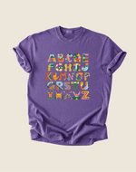 Purple t-shirt with colorful alphabet design on a beige background
