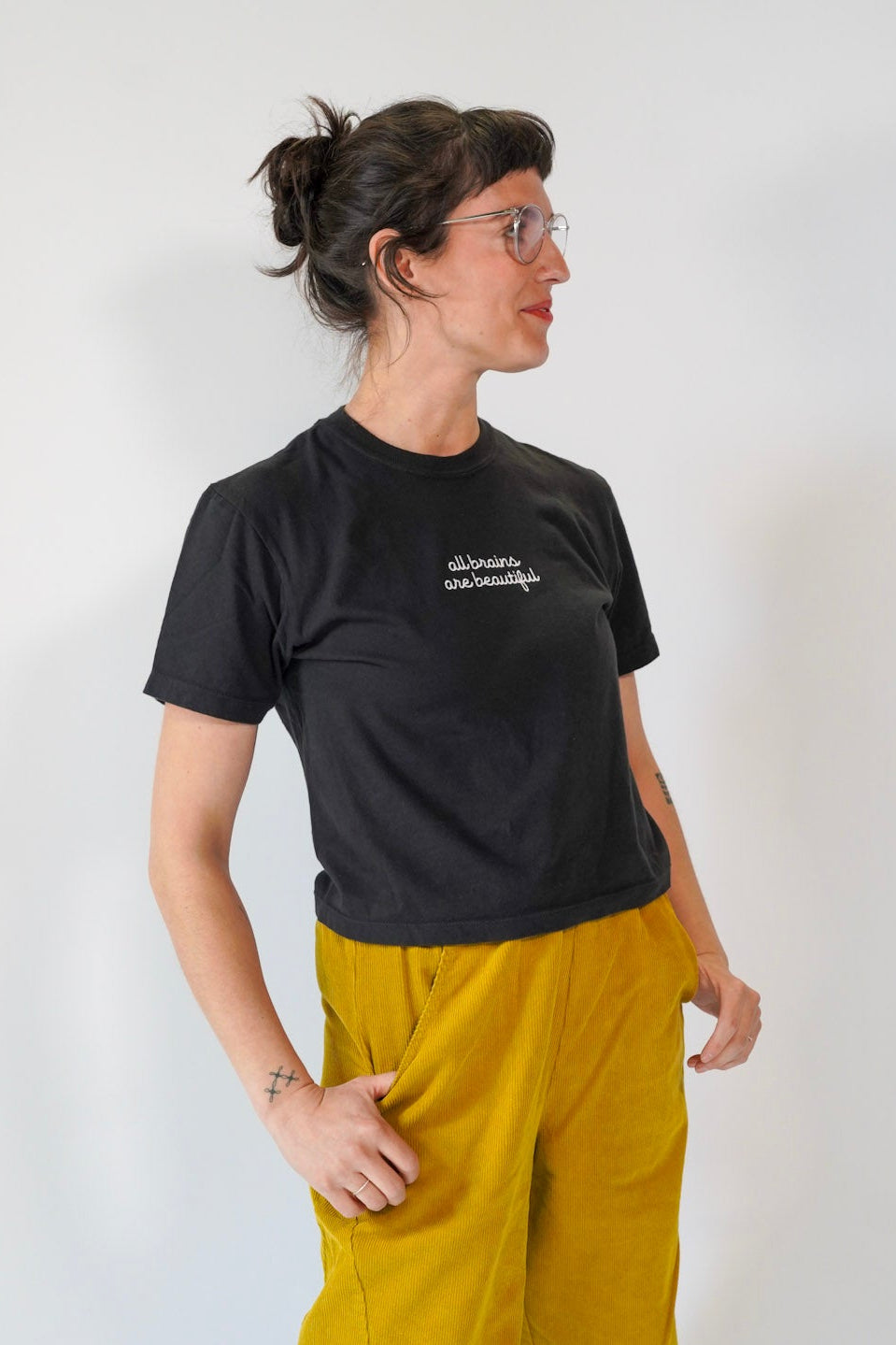 Person wearing a black t-shirt and yellow pants against a white background