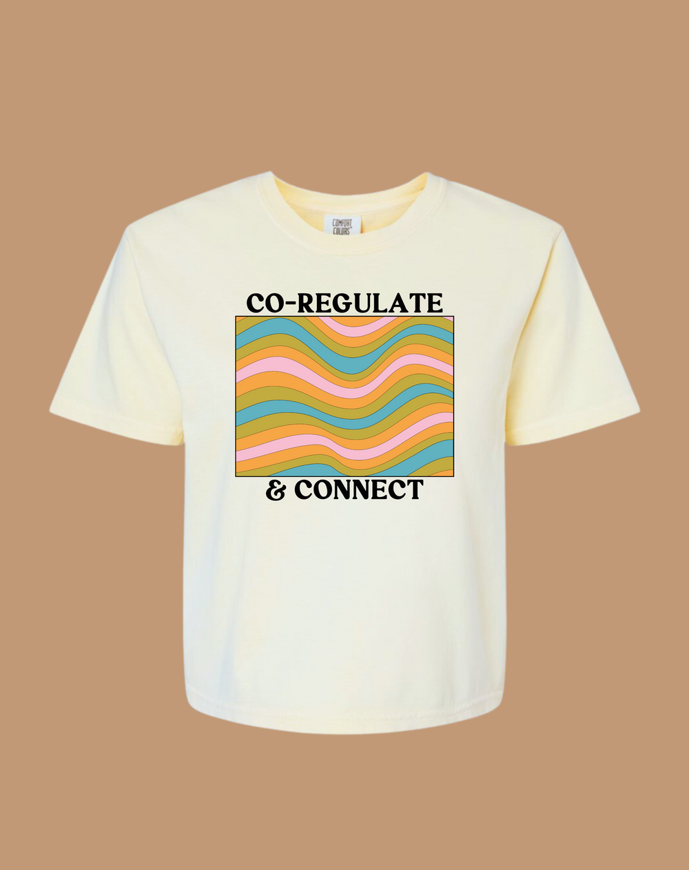 White t-shirt with colorful design and text on a brown background