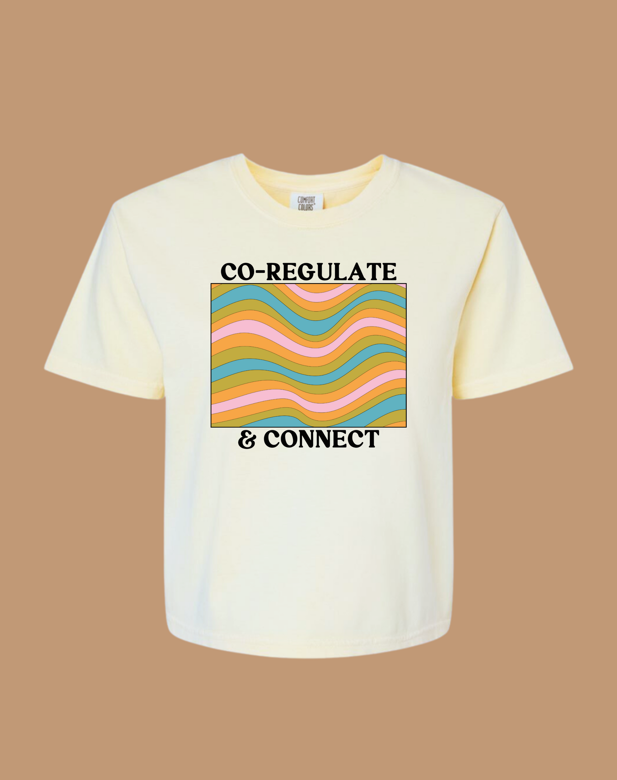 White t-shirt with colorful design and text on a brown background