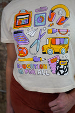 White t-shirt with colorful educational graphics and 'Education is for All' text.