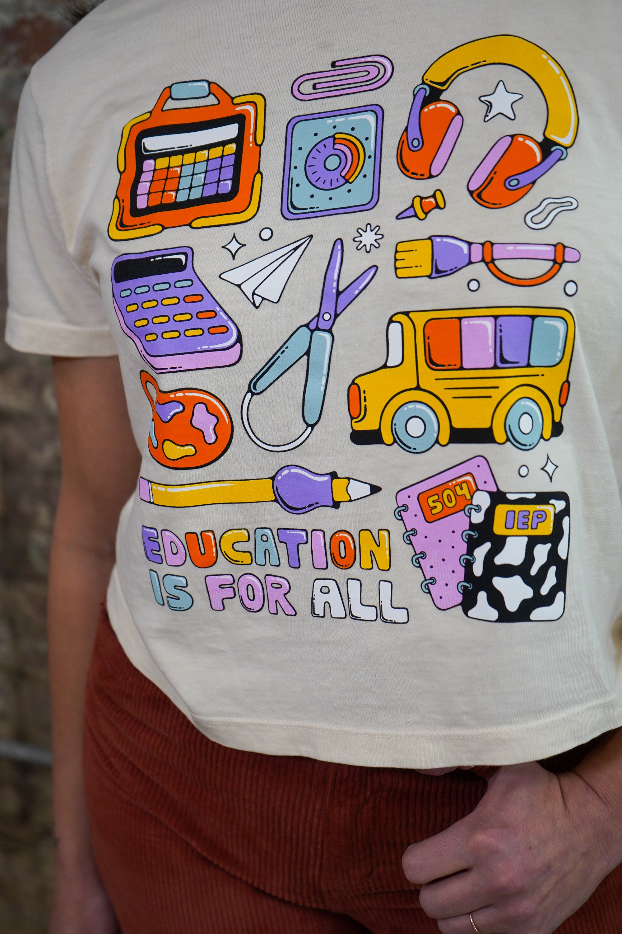 White t-shirt with colorful educational graphics and 'Education is for All' text.