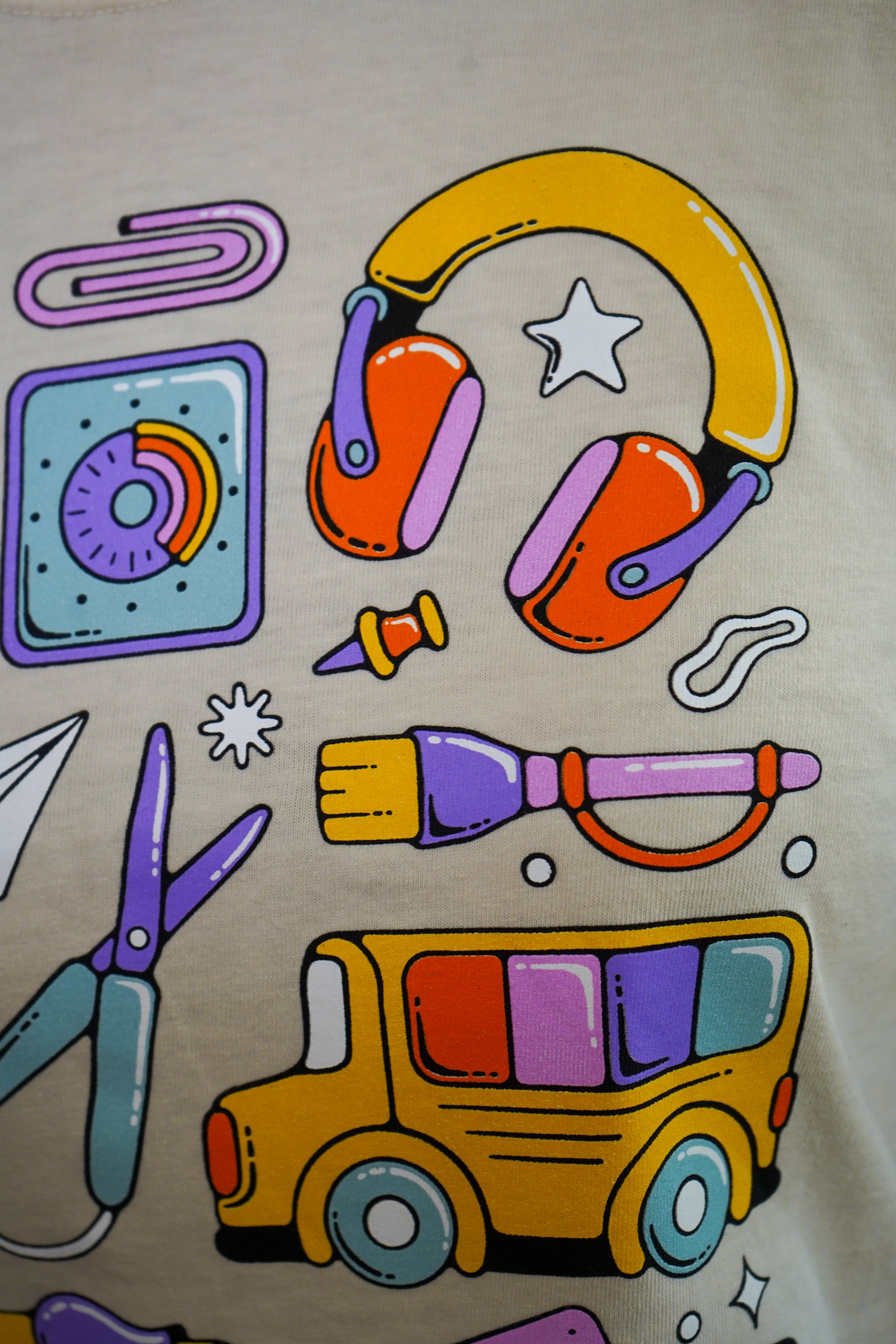 Colorful illustrations of a school bus, headphones, paper clips, and other items on a beige background.