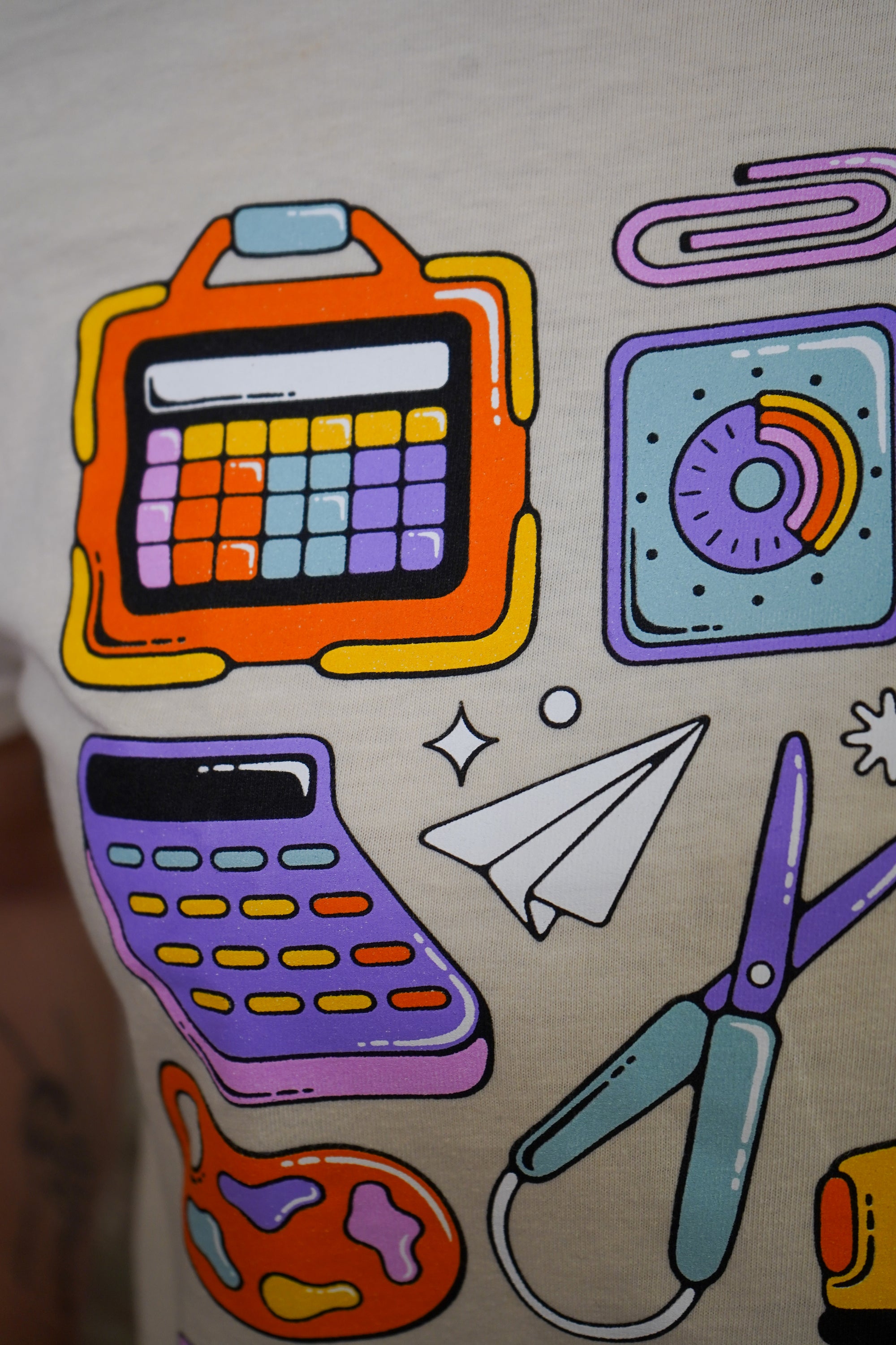 Colorful illustrations of a calculator, paper plane, scissors, and paper clips on a beige background.