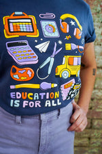 Navy blue t-shirt with colorful educational graphics and 'Education is for All' text, worn by a person.