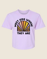 A pink crew neck t-shirt with the text 'MEET KIDS WHERE THEY ARE' and a multicolored semi-circle design behind the text.
