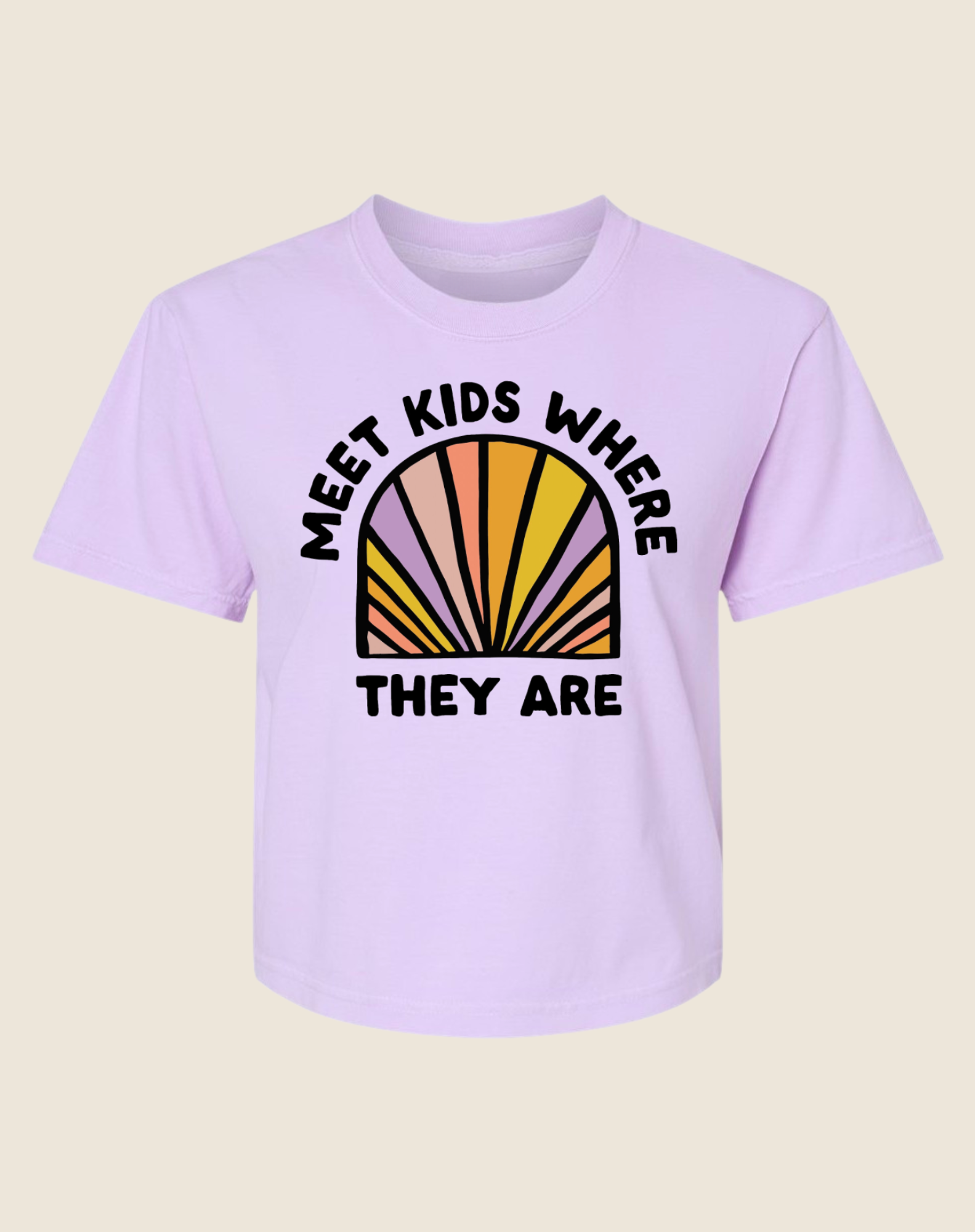 A pink crew neck t-shirt with the text 'MEET KIDS WHERE THEY ARE' and a multicolored semi-circle design behind the text.