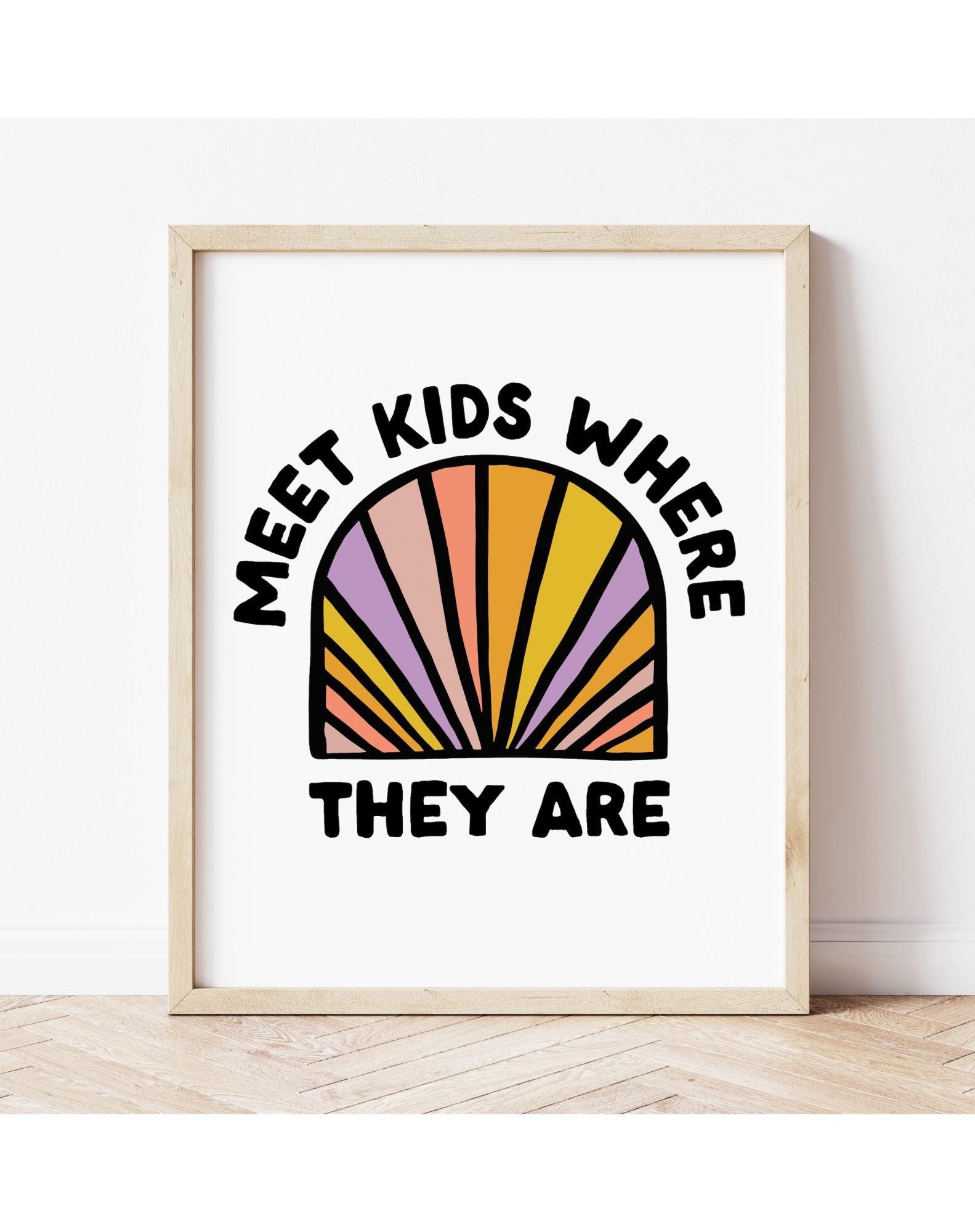 Play Spark Meet Kids Where They Are Print features a colorful arch design in shades of pink, orange, purple, and yellow, with bold black text. The print is displayed in a natural wooden frame, suitable for children's decor.