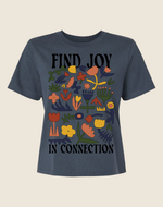 Navy blue t-shirt with colorful floral design and text 'FIND JOY IN CONNECTION' on a beige background