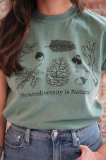 A person wearing a green t-shirt with an illustration and text related to neurodiversity.