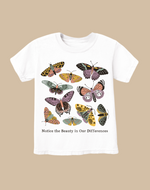 Play Spark Notice The Beauty In Our Differences Children's Tee in white, featuring a colorful butterfly graphic design with the text "Notice the Beauty in Our Differences" printed below. Ideal for casual wear.