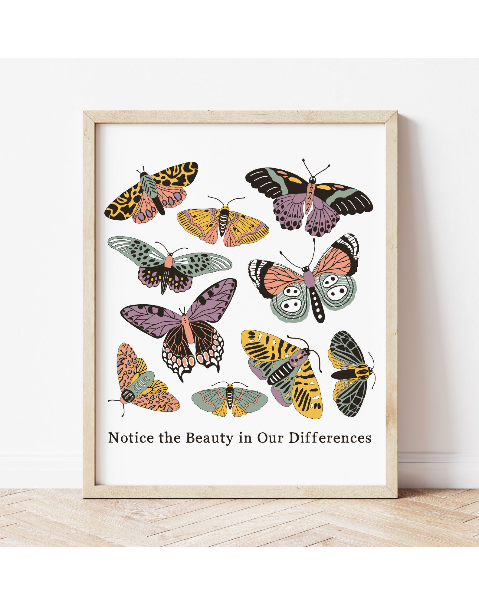 Play Spark Notice the Beauty in Our Differences Print featuring colorful illustrations of various butterflies with a light wooden frame, displayed against a minimalist background.