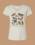 White t-shirt with colorful butterfly design and text on a beige background